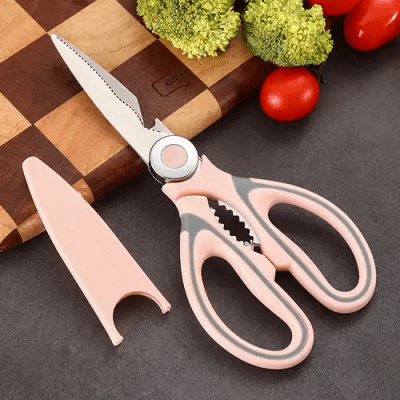 Ciseaux de cuisine multifonctions rose sur planche decouper