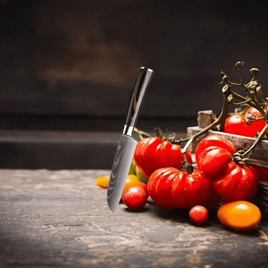 Couteau de cuisine du chef debout sur table avec tomates 
