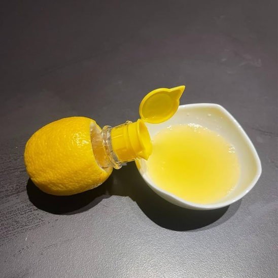 Presse agrume citron entier et jus de citron dans bol