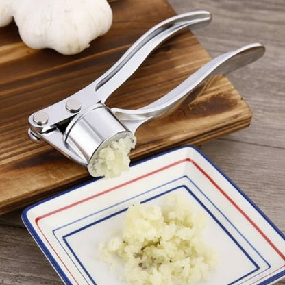 presse ail inox préparation ail en purée dans une assiette