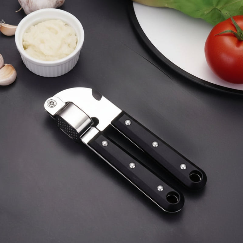 presse ail sur comptoir avec bol purée d'ail et assiette tomate