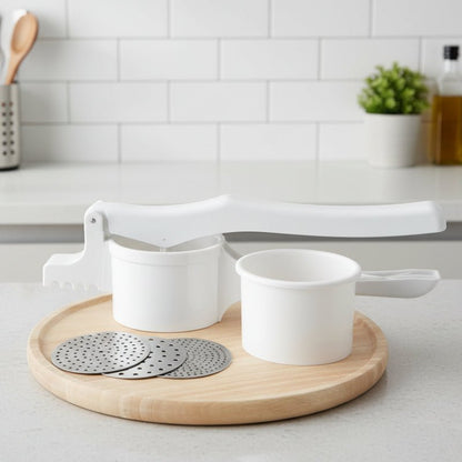 presse purée avec trois disques amovibles sur planche découper